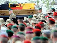 Trauerzeremonie im Feldlager Masar-i Scharif Ein Sarg mit Helm und Bundesdienstflagge, davor angetretene Soldaten