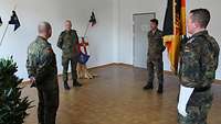 Vier Soldaten stehen im Abstand zueinander während des Übergabeappells.