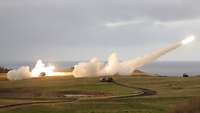 Ein Raketenwerfer verschießt eine Rakete. Es bilden sich ein Feuerstrahl und ein Rauchschweif.