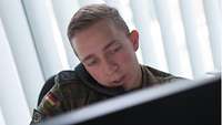 Ein Soldat spricht am Telefon