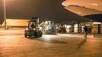 Mehrere Gabelstapler fahren die Ware vom Flugzeug über das Vorflugfeld