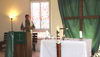 Militärpfarrer Jürgen Stahl am Altar, vor dem Altar brennt die Osterkerze