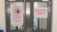 Tür mit der Beschriftung Quarantänestation 4 und Druchgang verboten Warnung