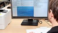 Die Sicherheitsüberprüfung in der Bundeswehr Mann sitzt am Schreibtisch und schaut auf einen Computer-Bildschirm