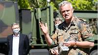 Generalarzt Dr. Bruno Most steht vor einem Lkw und spricht zu Klinikangehörigen und Pressevertretern.