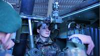 Ein Junge schaut durch die Optik im Panzermörser M113.
