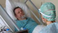 Patient liegt im Bett und spricht mit der Redakteurin