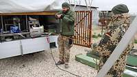 Ein Soldat und eine Soldatin räumen das Material wieder weg