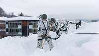 Soldaten beseitigen die Schneemassen auf einem Krankenhausdach