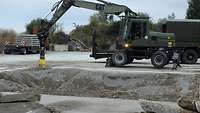 Ein Radlader steht auf kaputtem Beton. 