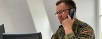 Soldat telefoniert zu Quarantänemaßnahmen
