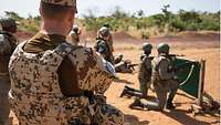 Ein deutscher Soldat beobachtet malische Soldaten beim Schießen