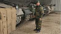 Ein Soldat steht neben einer Reihe von Panzern