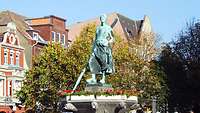 Der Tine-Brunnen in Husum Oben auf dem sogenannten Tine-Brunnen in Husum steht die Statue eines Fischermädchens aus Bronze. Das ist die Tine.