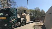 Lastwagen, der auf seinem tiefen Auflieger ein großes rechteckiges Bauelement transportiert