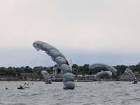 Kampfschwimmer Fallschirmsprung Wasserung Vier Fallschirmspringer mehrere Meter über dem Wasser vor einer Küste.