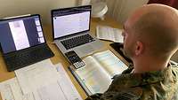Ein Lehrgangsteilnehmer sitzt am Schreibtisch. Vor ihm: Laptop und aufgeschlagene Bücher