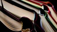 übereinanderliegende, aufgeklappte Bücher