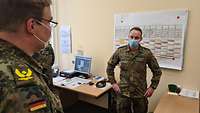 Zwei Soldaten stehen in einem Büro. 