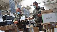 Zwei Feldpostsoldaten überprüfen hereinkommende Post.