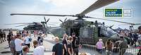 Besucher stehen vor dem Mehrzweckhubschrauber NH-90, rechts im Bild das Logo Digitaler Tag der Bundeswehr 2020