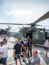 Besucher stehen vor dem Mehrzweckhubschrauber NH-90, rechts im Bild das Logo Digitaler Tag der Bundeswehr 2020