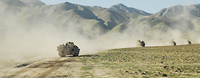 Schützenpanzer Marder in Afghanistan Vier Panzer fahren in weitem Abstand hintereinander. Dahinter erstreckt sich eine steinige Gebirgskette.