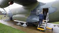Ein Soldat steigt über eine Treppe in ein Transportflugzeug vom Typ Transall ein