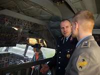 Zwei Soldaten stehen im Cockpit eines Transportflugzeuges vom Typ Transall und unterhalten sich