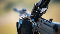 Nahaufnahme eines Maschinengewehrs MG4 A3 mit Patronentasche und Gurt