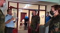 Im Flur vor der Anmeldung zur Sprechstunde unterhalten sich vier Soldatinnen und Soldaten