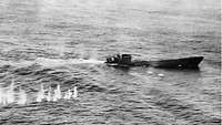 U-Boot-Krieg 1944 U426 Schwarzweiß-Aufnahme eines U-Boots an der Wasseroberfläche; im Wasser weiße Spitzer von einschlagenden Geschossen.