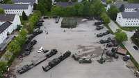 Luftbildaufnahme mit Militärfahrzeugen auf einem großen Betonplatz