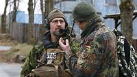 Zwei Soldaten stehen nebeneinander und unterhalten sich.
