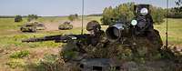 Soldaten der Bundeswehr üben im Gelände. Zwei Soldaten auf einem Waffenträger Wiesel im Gelände, im Hintergrund fahren zwei Panzer