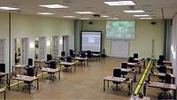 In einem großen Saal stehen 20 mit Telefon und Laptop ausgestattete Arbeitsplätze bereit.