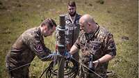 Drei Soldaten bauen einen Antenne für Link 16 auf.