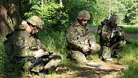 Ein Soldat erzählt etwas, zwei andere hören zu