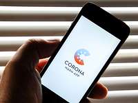 Corona-Warn-App Eine Hand hält ein Smartphone, auf dem das Logo der Corona-Warn-App der Bundesregierung angezeigt wird