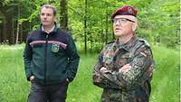 Porträt eines Soldaten und eines zivil gekleideten Mannes im Wald.