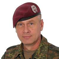 Ein Soldat mit rotem Barett schaut in die Kamera.