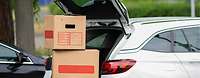 Umzugskartons vor einem Auto Umzugskartons vor einem Auto