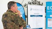 Generalleutnant Markus Laubenthal ist im Vordergrund zu sehen. Stellwände mit Informationen zum Aktionsprogramm "Modernes Führen