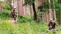 IT-Soldaten im Wald mit Sense auf einem Hang