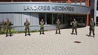Mehrere Soldaten stehe vor einem Gebäude mit dem Schriftzug Landkreis Heidekreis