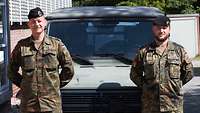 Zwei Soldaten stehen vor einem militärischen Fahrzeug