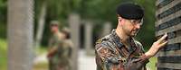 Ein Soldat berührt eine Namensstele im „Wald der Erinnerung“.