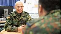 Zwei Soldaten sitzen an einem Tisch und unterhalten sich