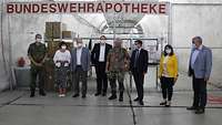 Gruppenbild in der Untertageanlage vor dem Schild Bundeswehrapotheke