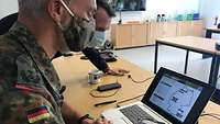 Ein Soldat an einem Laptop